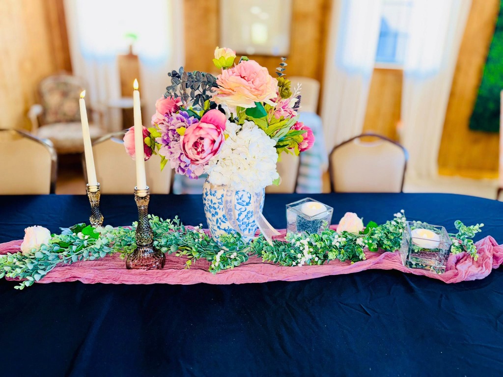 Close up of table setting with pink table runner and floral centerpiece