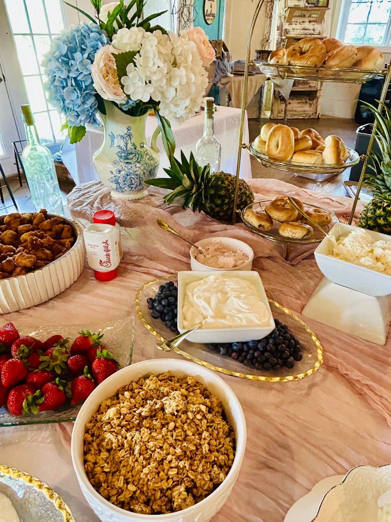 Food display with a tiered tray of bagels, fruit, and yogurt