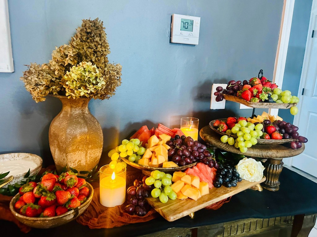 Fruit, cheese, and charcuterie spread with grapes, melon, and strawberries