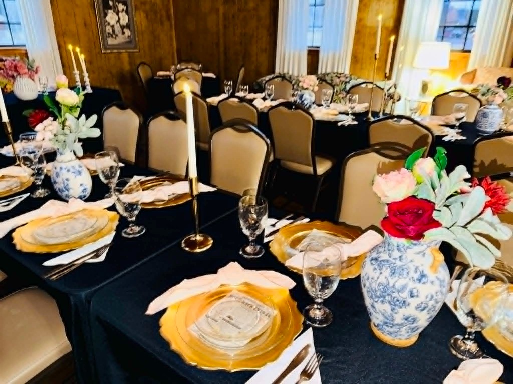 A beautifully decorated table setting with flowers, candles, and elegant plates
