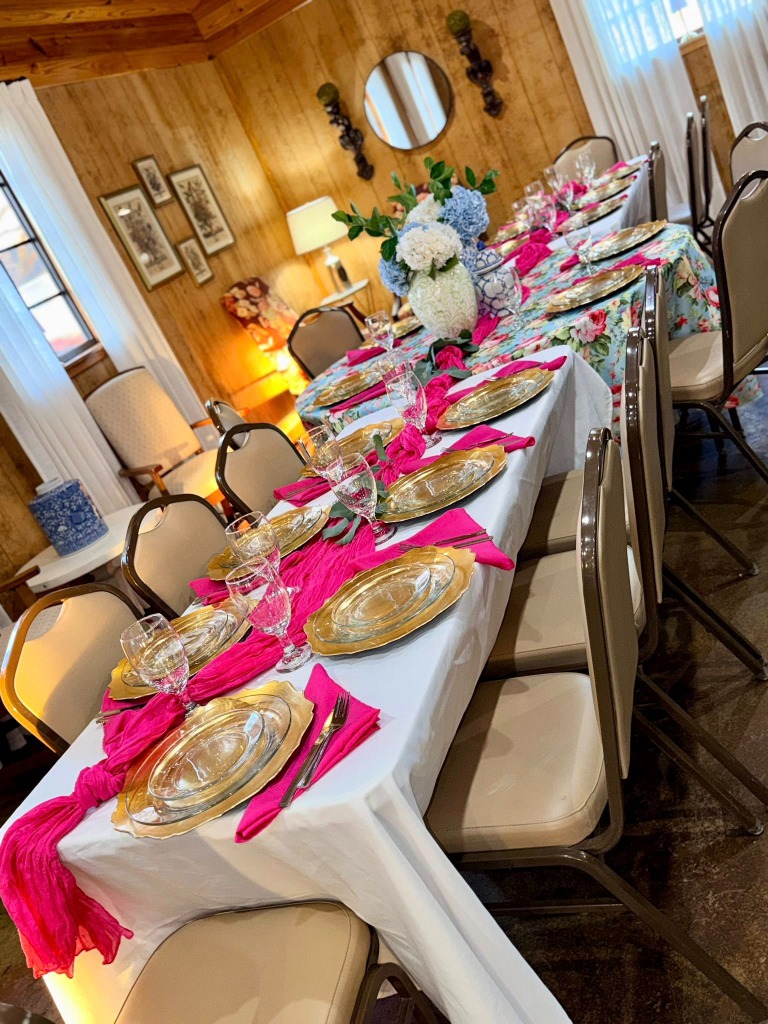 Long table setting with pink runners and floral tablecloths