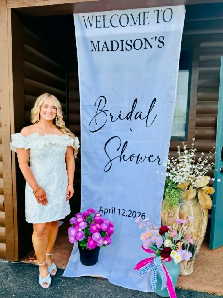 Woman standing next to a Welcome to Madison's Bridal Shower sign
